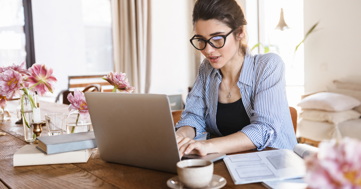 woman with glasses working on laptop